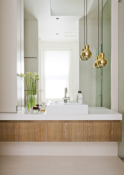 Modernes Licht im Bad großer Wandspiegel Pendelleuchten unterschiedliche Höhe goldener Glanz schickes Design