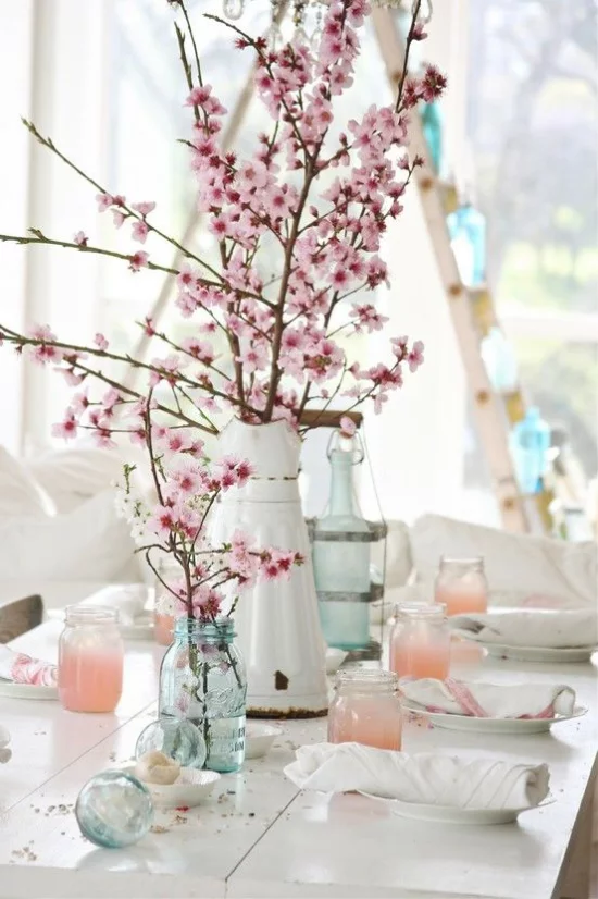 Frühlingsdeko mit Kirschblüten in verschiedenen Gefäßen schmücken den Esstisch rustikaler Touch