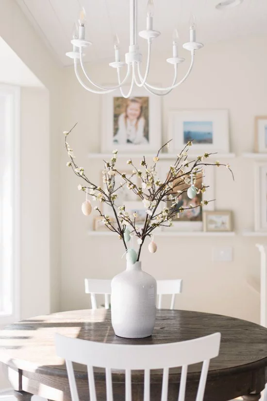 Frühlingsdeko mit Kirschblüten runder Esstisch Vase mit Kirschzweigen Ostereier schöner Schmuck im Esszimmer