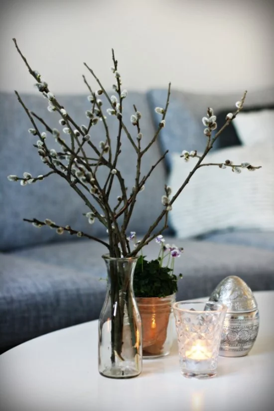 Frühlingsdeko mit Weidenkätzchen Zweige in Vase arrangiert auf dem Kaffeetisch vom Floristen kaufen