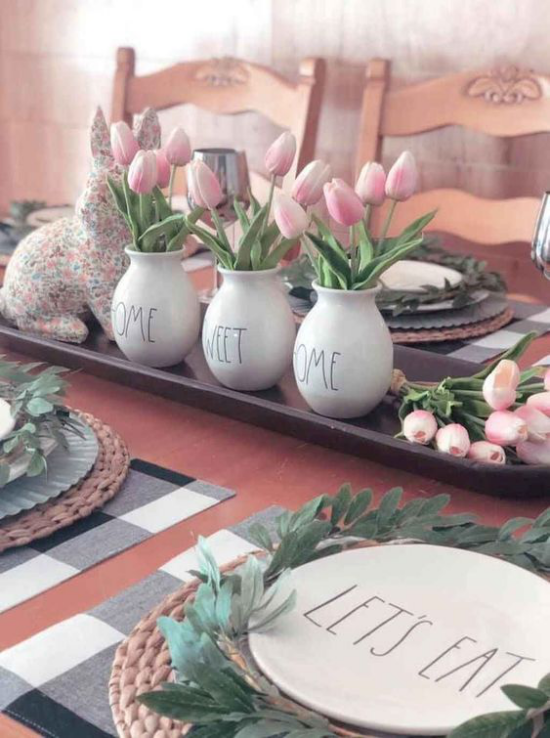 Küche frühlingshaft dekorieren auf Tablett drei weiße Porzellanvasen voll mit hellrosa Tulpen festlich dekorierter und gedeckter Tisch