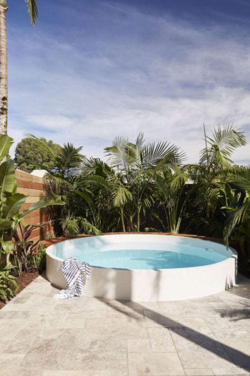 Runde Gartenpools Schwimmbecken im Hinterhof üppiges Grün Palmen als Sichtschutz Dschungel-Feeling