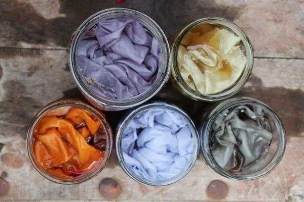 Stoffe und Textilien färben im Farbbad in verschiedene Farben