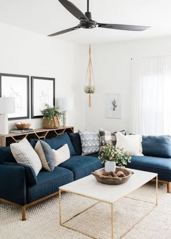 Wohnzimmer optisch erweitern weiß und dunkelblau im Kontrast viel Tageslicht keine Grenzen dunkles Sofa als Akzent