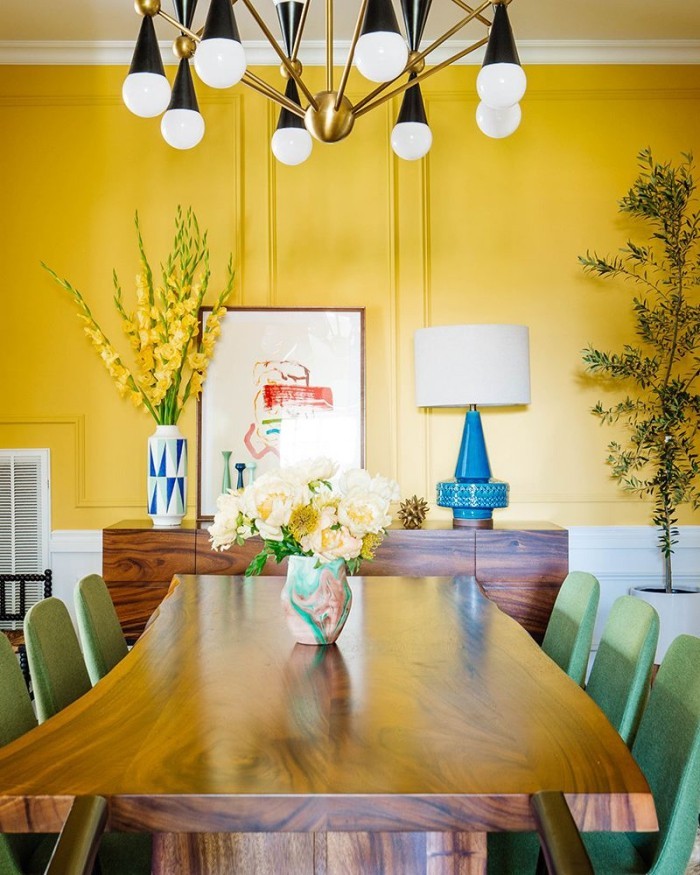 Geheimnisse des Innendesigns enthüllt Esszimmer in warmem Sonnengelb ausgeführt gelbe Wand hellgrüne Stühle gelbe Gladiolen in großer Vase