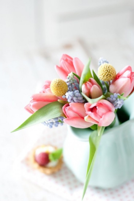 Osterdeko in Pastellfarben Blumen in zarten Farbtönen in Vase bringen eine fröhliche Note mit auf den Ostertisch