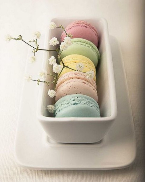 Osterdeko in Pastellfarben Maccarons in Pastelltönen sehen lecker aus weiße Blüten als Schmuck im weißen Geschirr