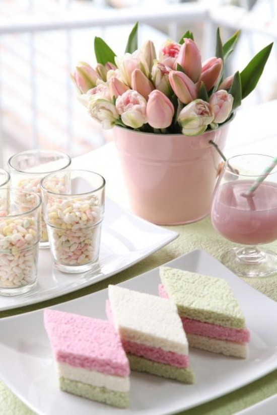 Osterdeko in Pastellfarben gedeckter Tisch Kuchenstücke in Pastell Tulpen Saft im Glas