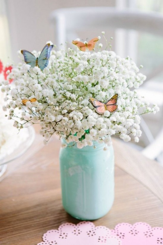 Osterdeko in Pastellfarben weiße Blüten von der Wiese im Glas als Blickfang Schmetterling