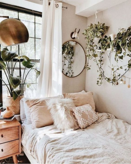 Schlafzimmer luxuriöse Touches Gemütlichkeit pur bequemes Bett weiche Kissen grüne Pflanzen Lampe in Metallic Glanz
