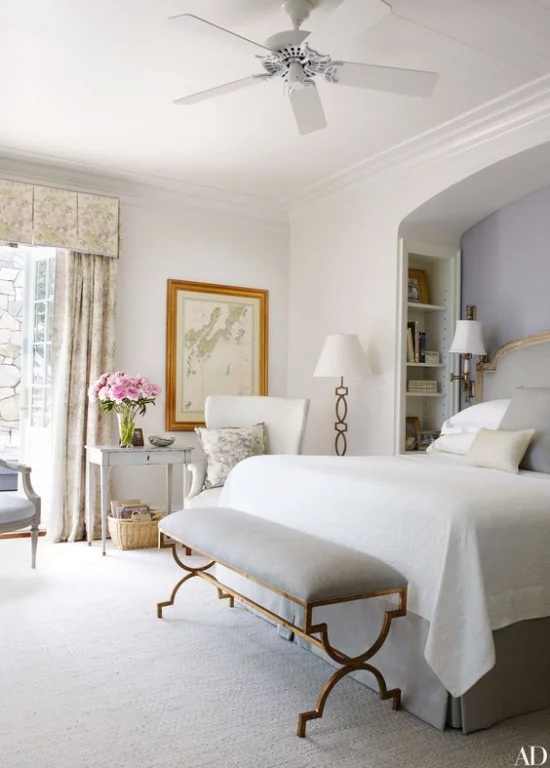 Schlafzimmer luxuriöse Touches elegante Sitzbank mit Metallbeinen Stehlampe neben dem weißen Sessel in der Ecke