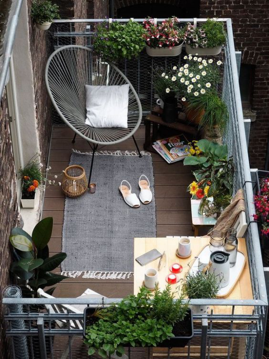 Terrasse frühlingsfit machen Ideen auch für kleinen Balkon frühlingshaft gestalten schöne Blumen Sessel aus Metall grauer Teppich