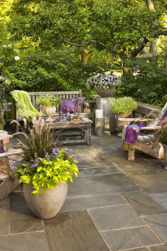 Terrasse frühlingsfit machen alte Holzmöbel Behälter mit Blumen und Grünpflanzen