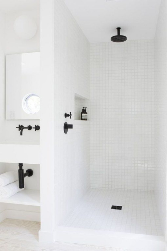 Badezimmer ganz in Weiß Badarmatur in Schwarz farbige Akzente durchbrechen die Eintönigkeit