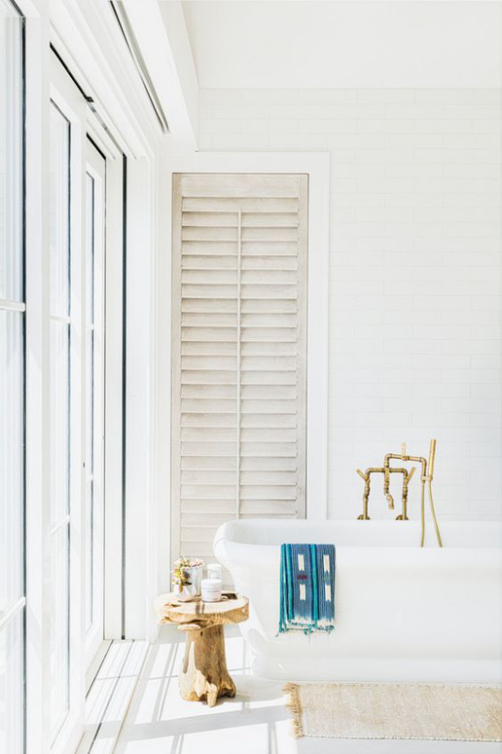 Badezimmer ganz in Weiß Holzhocker vor dem Fenster betont den Vintage Look