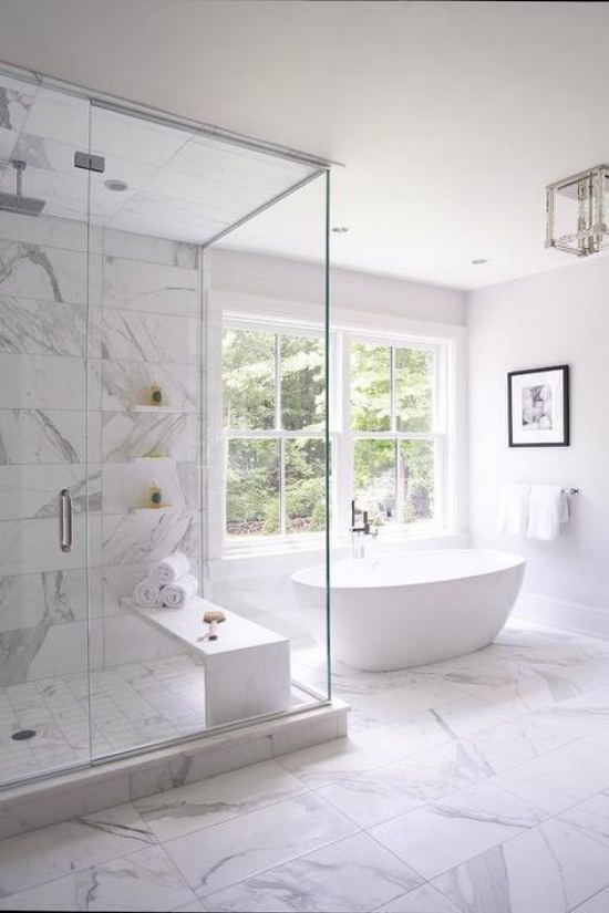 Badezimmer ganz in Weiß Marmorfliesen viel natürliches Licht freistehende Badewanne Dusche Glaswände