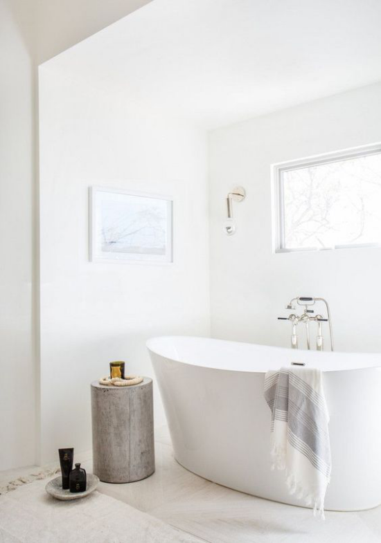 Badezimmer ganz in Weiß freistehende Badewanne Baumstamm als Blickfang viel natürliches Licht