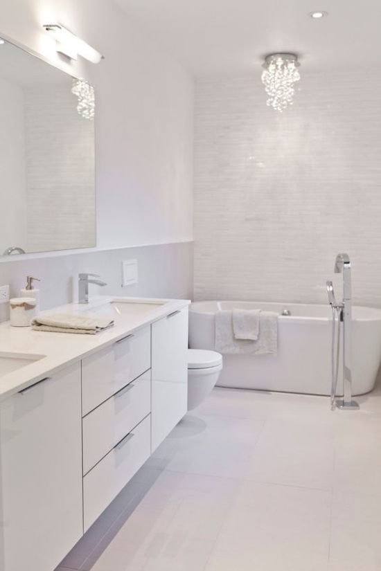 Badezimmer ganz in Weiß künstliche Beleuchtung Spiegellampe Deckenstrahler kleiner Kronleuchter Blickfang