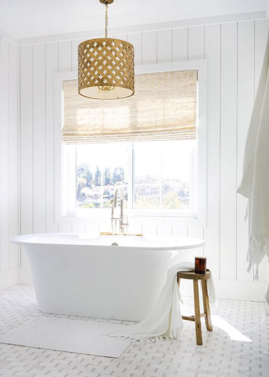 Badezimmer ganz in Weiß schöne freistehende Badewanne vor dem Fenster viel Licht Rollos zum Schichtschutz