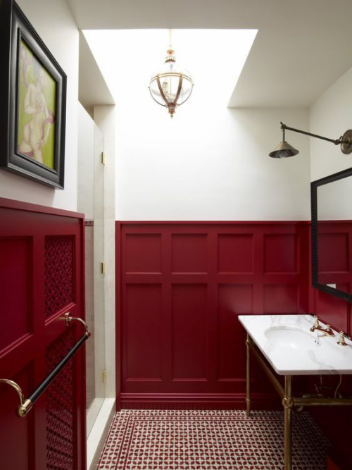 Badezimmer in Rot dunkelrote Wandvertäfelung weißer Waschtisch rechts Spiegel Leuchte links Wandbild