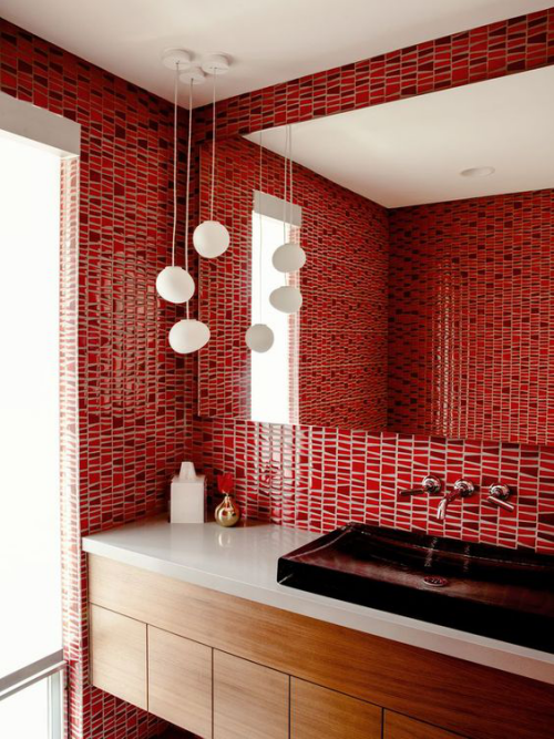 Badezimmer in Rot rote Fliesen an den Wänden großer Wandspiegel weiße Hängeleuchten weißer Waschtisch kleine Badaccessoires