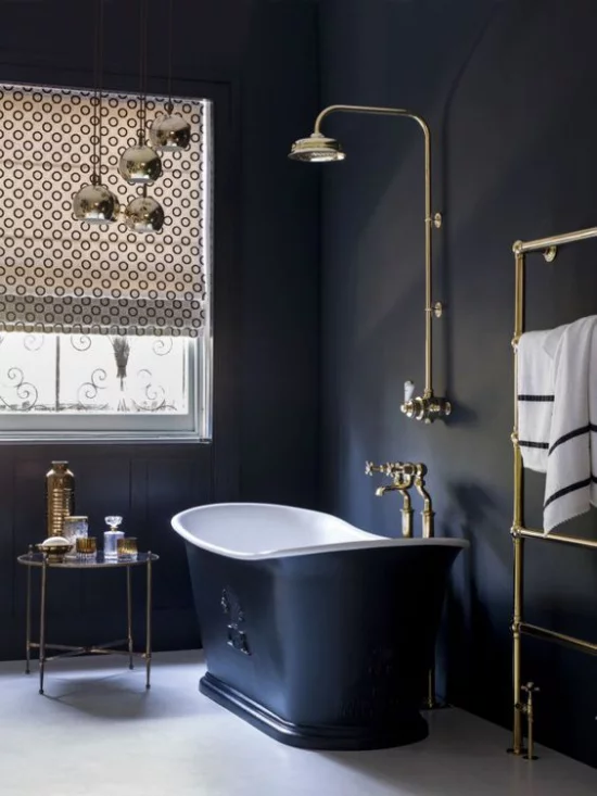 Badezimmer in Schwarz und Gold freistehende Badewanne in dunkelblau helle Armaturen Tageslicht