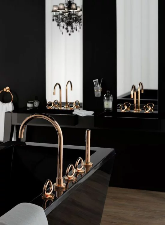 Badezimmer in Schwarz und Gold schwarze Badewanne Waschtisch Armaturen in Gold zwei Spiegel weiße Tücher