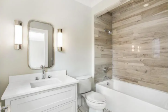 Badfliesen in Holzoptik geräumiges Bad WC Weiß dominiert Badewanne Akzentwand mit Fliesen