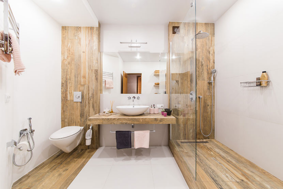 Badfliesen in Holzoptik großes Bad und WC in einem Raum symmetrisch gestaltet Duschecke mit Glaswand getrennt