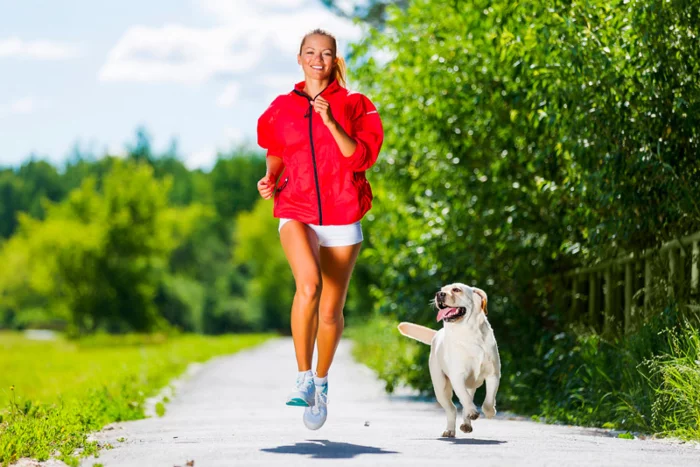 Corona-Krise und Hunde junge Frau joggen in Begleitung ihres Hundes