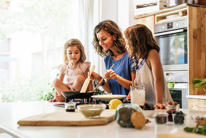 Corona-Krise zuhause was machen Mutter zwei Töchter in der Küche zusammen kochen