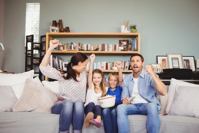 Corona-Krise zuhause was machen vierköpfige Familie auf der Couch zusammen fernsehen Spaß haben