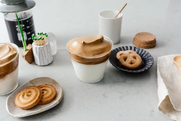 Dalgona Coffee neues trendiges Kaffeegetränk mit Kleingebäck für zwischendurch serviert