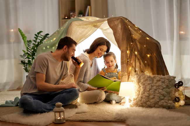 Stress vermeiden während Coronavirus Pandemie Familie zu Hause mit dem Kind spielen Zelt Bücher lesen
