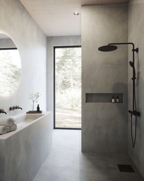 Baddesigns in Grau schönes Bad Duschecke schwarze Armatur langer Waschtisch Glastür runder Wandspiegel