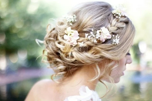 Brautfrisur hochgesteckt mit Blumen romantische Locken