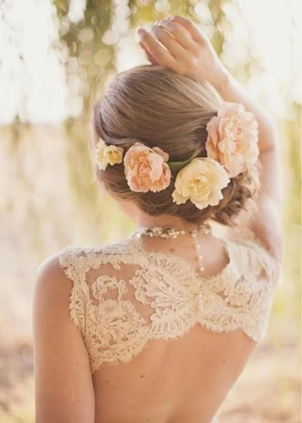 Brautfrisur mit Blumen ohne Schleier hochgesteckt niedriger Dutt