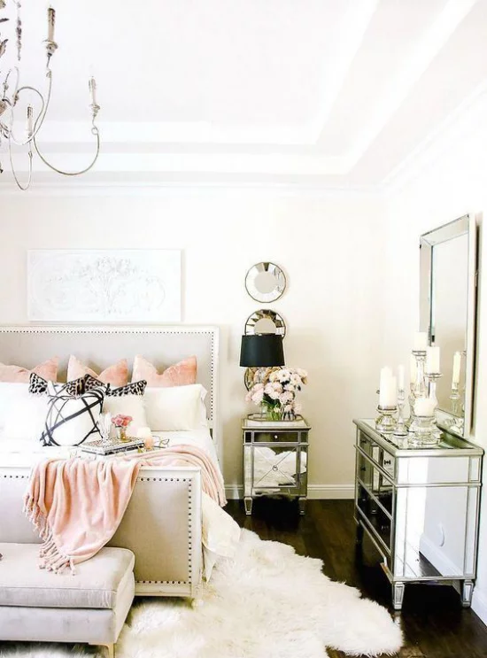 Glamouröse Schlafzimmer Glanz vom Boden bis zur Decke Weiß dominiert kleine rosafarbene Akzente Wurfdecke Kissen Kristallkronleuchter