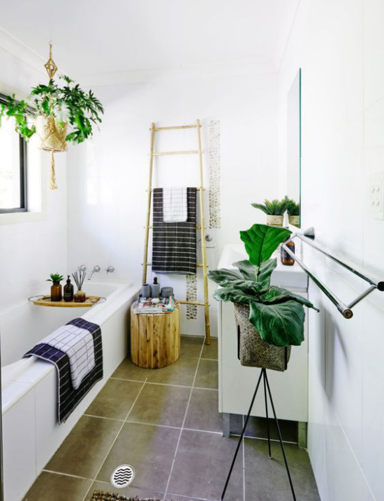 Grün im Bad Badewanne weißes Badezimmer viele Grünpflanzen viel Tageslicht Leiter