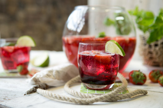 Sommerbowle zubereiten frisch lecker fruchtig Erdbeeren Zitronenscheiben Eiswürfel im Glas
