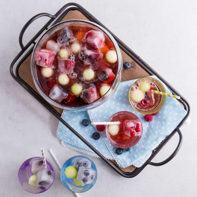 Sommerbowle zubereiten frisch lecker fruchtig Früchte Himbeeren Brombeeren in Eisformen eingefroren