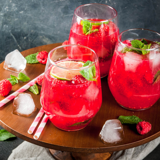 Sommerbowle zubereiten frisch lecker fruchtig drei Gläser Strohhalme Erdbeeren Zitronenscheiben Eiswürfel Minze