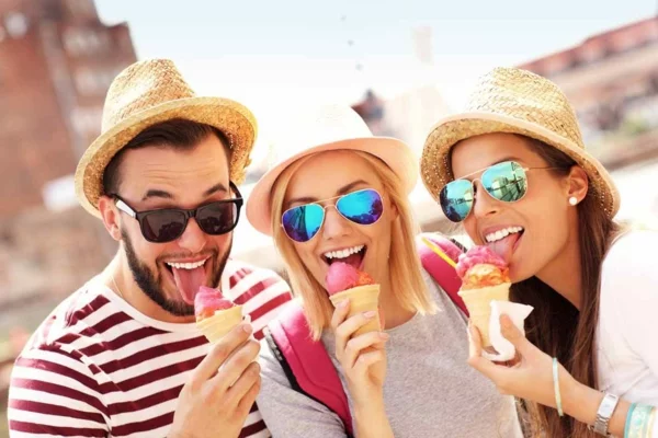 Ausgefallene Eissorten drei junge Menschen reisen gern und essen Eis fröhliche Gesicher