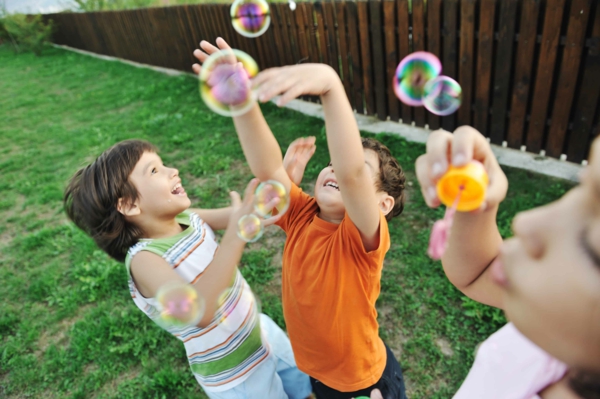 Gartenspiele für Kinder im Freien spielen Seifenblasen jagen