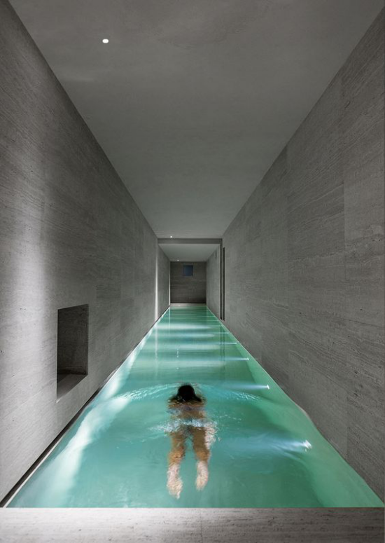 Hallenbad zu Hause Minimalismus pur längliche Form Mädchen im Wasser graue Fliesen eingebaute Beleuchtung