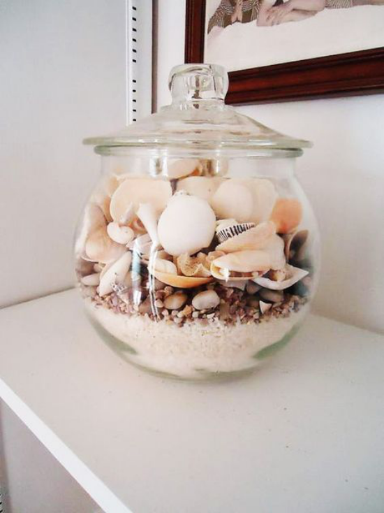Sommerdeko mit Muscheln Glasschale mit Deckel auf der Kommode gefüllt Muscheln Sand Granulat Steine