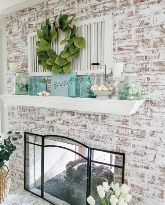 Kaminkonsole sommerlich dekorieren Ziegelwand geschmückt Glasplatte