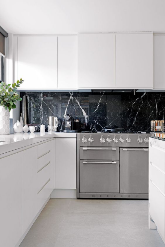 Schwarzer Marmor im Interieur moderne Küche weiße Schränke schwarze Küchenrückwand aus Marmor graue Küchengeräte