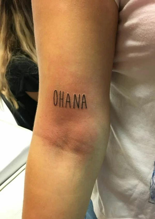 Oberarm-Tattoo mit Ohana Schriftzug in großen Buchstaben 