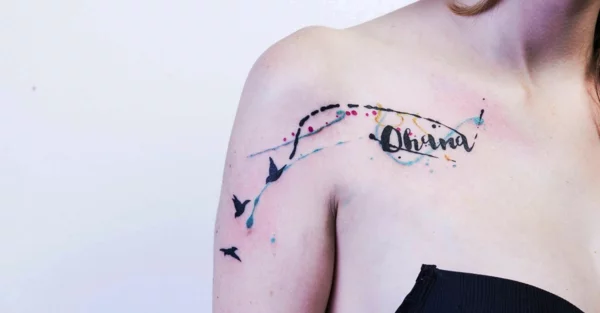 Schulter-Tattoo in Aquarell mit Ohana-Schriftzug und Vögeln 